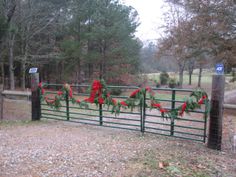 a fence with wreaths and red ribbons on it