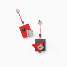 two red and black square shaped earrings with buttons on the back, hanging from strings