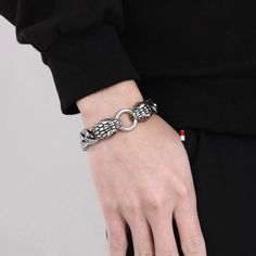 a person wearing a black shirt and silver bracelet with a chain on it's wrist