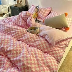 a pink and white checkered comforter on a bed