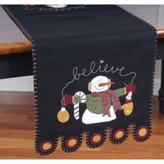 a black table runner with a snowman on it