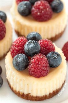 three small desserts with berries and blueberries on top