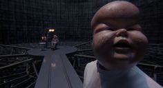 a creepy looking baby is standing in front of a camera man with his mouth open