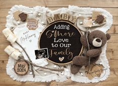 a teddy bear and other baby items are arranged on a wooden surface with the words, saying