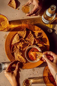 people are eating food and drinking beer on the table