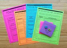 three different colored papers sitting on top of a wooden table next to an orange and pink binder