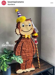 a paper cut out of a monkey with a party hat and holding a broom on top of a table