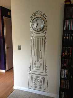 a clock is on the wall next to a bookshelf