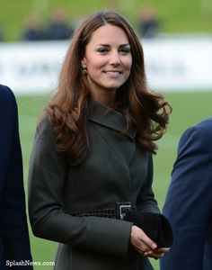 the duke and duchess of cambridge smile as they stand next to each other at an event