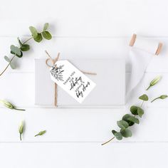 a white envelope with greenery tied to it and a thank card on the front