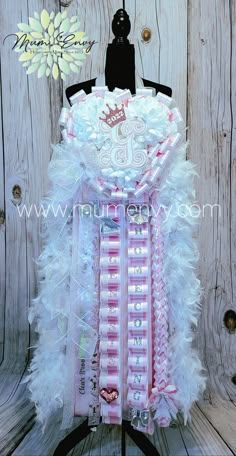 a dress made out of feathers on a mannequin headdress with a flower in the background