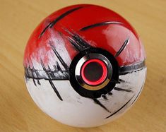 a red and white ball sitting on top of a wooden table