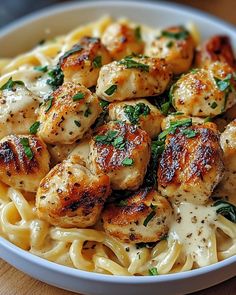 pasta with scallops and spinach in a white bowl on a wooden table