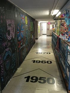 a long hallway with graffiti on the walls and numbers painted on the floor in different colors