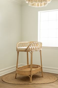 a wicker chair sitting on top of a wooden floor next to a round rug