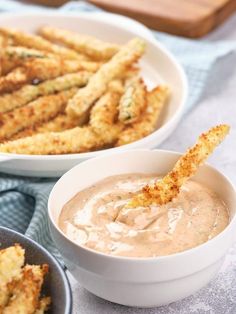 two bowls filled with dipping sauce next to some fried food