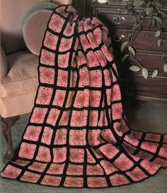 a pink and black blanket sitting on top of a chair