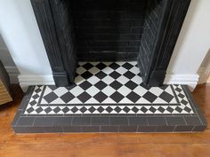 a black and white tile floor with a fireplace in the corner, next to a brick fire place