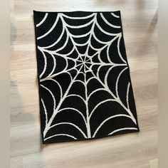 a black and white spider web rug on the floor