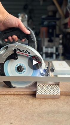 a person using a circular saw to cut wood