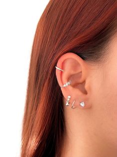 a close up of a person wearing ear piercings with hearts on it's sides