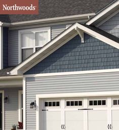 two white garage doors in front of a blue house with the words northwood written on it