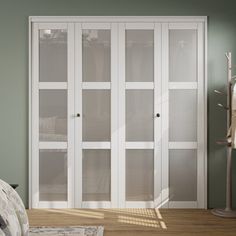 a bedroom with green walls and white closets next to a bed in the corner