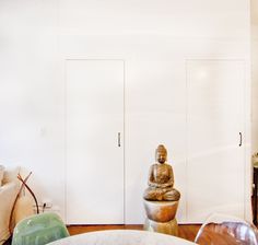 a living room filled with furniture and a buddha statue