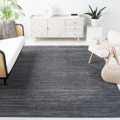 a black and white rug in a living room next to a couch, chair and table