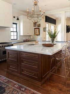 a large kitchen with an island in the middle and chairs at the counter top,