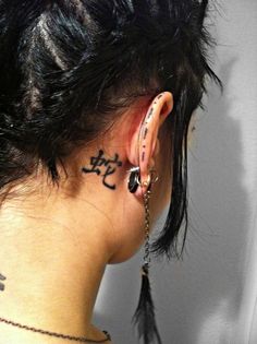 the back of a woman's head with tattoos on her neck and behind ear