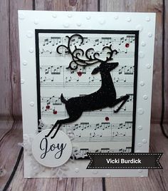 a card with a reindeer on it and music notes in the background that says joy