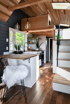 an open concept kitchen and dining area with wood flooring, white countertops and black walls