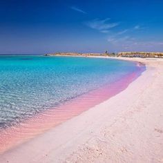 the water is crystal blue and pink in this beach scene, with white sand on the shore