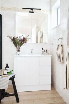 a bathroom with a sink, mirror and towel rack on the wall in front of it