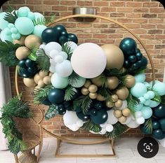 the balloon arch is decorated with green, gold and white balloons