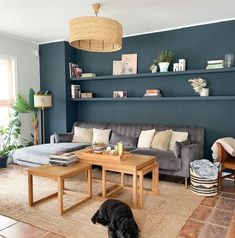 a living room filled with furniture and a dog laying on the floor next to it