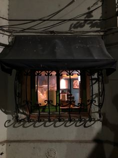 a window with a black awning over it and a light in the window behind it