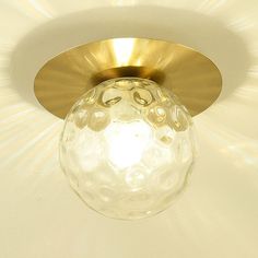 a light fixture with a glass ball hanging from it's center point on the ceiling