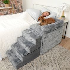 a woman laying on top of a bed next to a dog