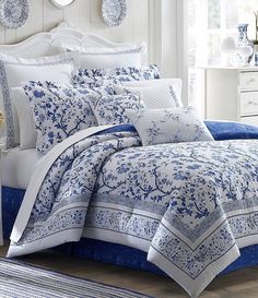 a bed with blue and white comforters in a room