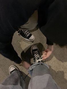 two people standing next to each other on the floor with their feet up and shoes down