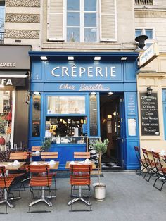 the outside of a restaurant with tables and chairs