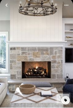 a living room filled with furniture and a fire place in front of a stone fireplace