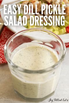 a salad dressing in a small glass bowl next to a white plate and red napkin