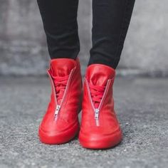 a person wearing red shoes with zippers on them