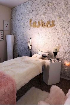 a bedroom decorated in white and pink fur with gold letters on the wall above it