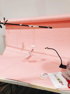 a pink table with a light and some items on it