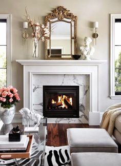 a living room filled with furniture and a fire place in front of a mirror on top of a fireplace