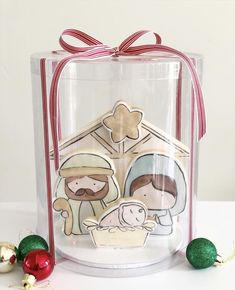 a clear gift box with a nativity scene inside